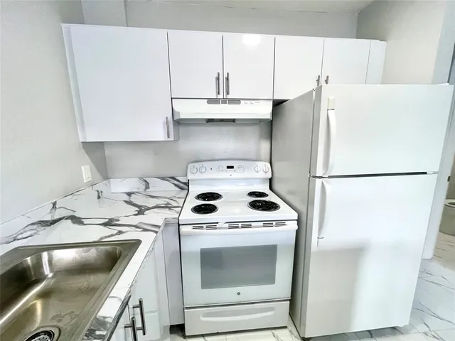 a kitchen with a white stove top oven and refrigerator