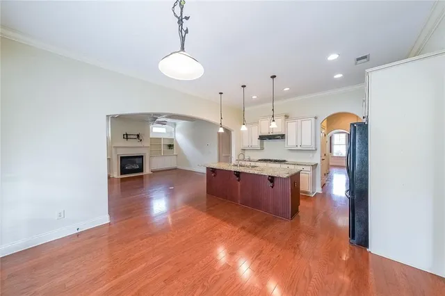 a large kitchen with a lot of counter space and wooden floor