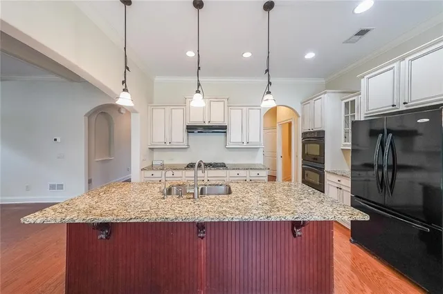a bathroom with a granite countertop sink and a refrigerator