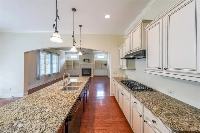 a kitchen with kitchen island granite countertop a stove oven and a white cabinets