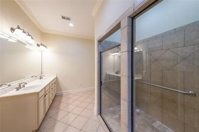 a spacious bathroom with a double vanity sink a mirror and a shower