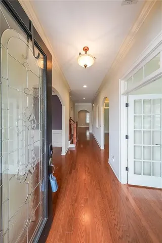 a view of a hallway with wooden floor and staircase