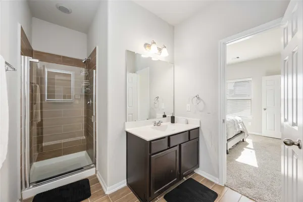 a en suite bathroom with a sink mirror and shower