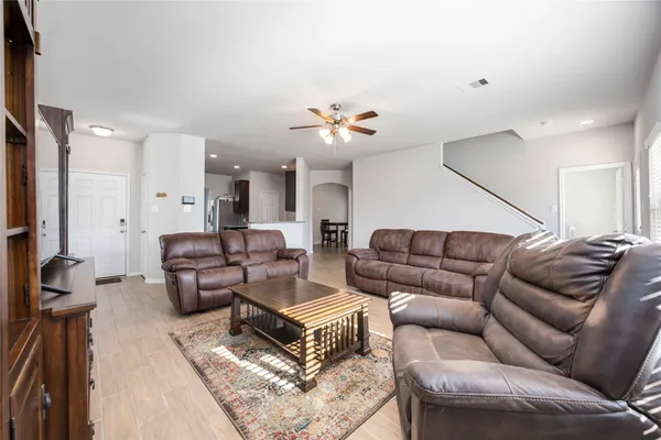 a living room with furniture a ceiling fan and a rug