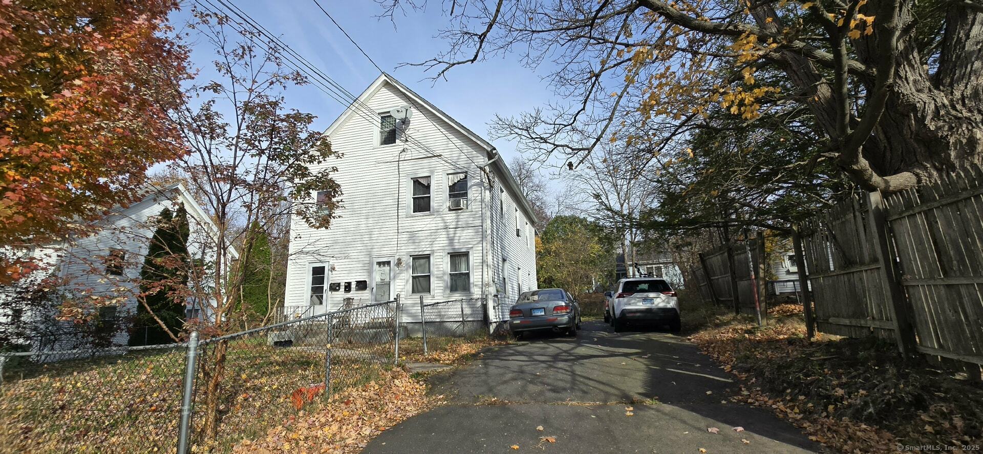 40 Maple Place Middletown, CT 06457 - Photo 4 of 6 a view of a white house next to a yard with a fountain and large trees