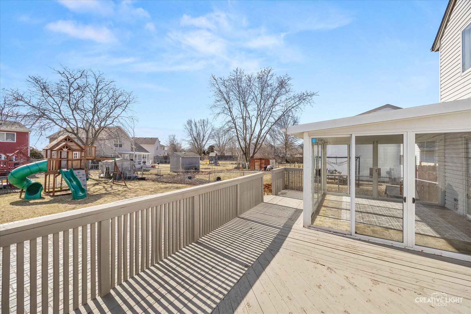 1221 Longford Circle Elgin, IL 60120 - Photo 26 of 29 a view of a balcony with wooden floor and fence and a couple of cars parked in front of it