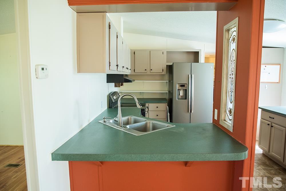 800 Woodsdale Road Roxboro, NC 27574 - Photo 16 of 54 a kitchen with stainless steel appliances granite countertop a sink and a refrigerator