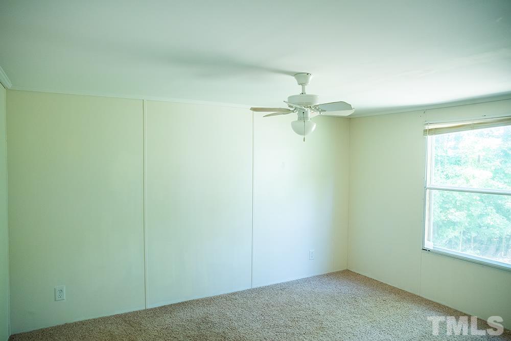 800 Woodsdale Road Roxboro, NC 27574 - Photo 36 of 54 an empty room with a window and a chandelier fan
