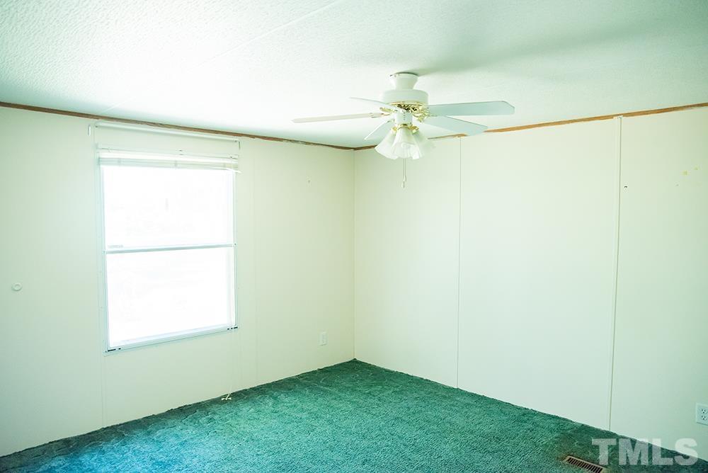 800 Woodsdale Road Roxboro, NC 27574 - Photo 38 of 54 an empty room with a window and a ceiling fan