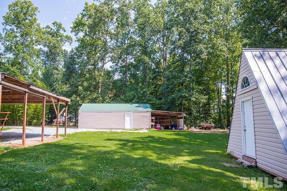 800 Woodsdale Road Roxboro, NC 27574 - Photo 46 of 54 a view of a backyard with a garden and deck