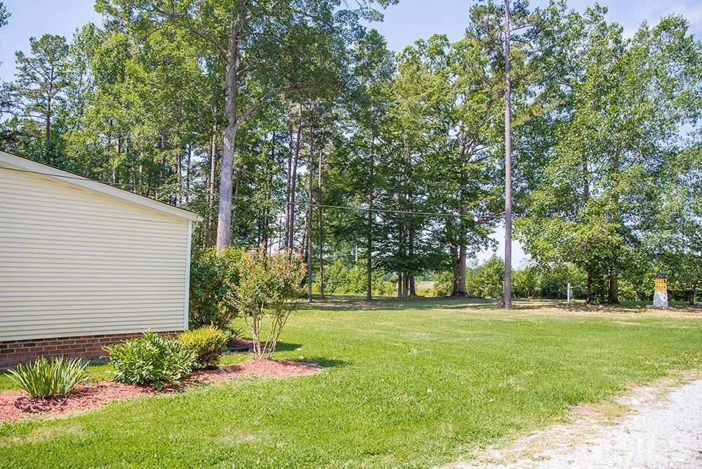 800 Woodsdale Road Roxboro, NC 27574 - Photo 50 of 54 a garden with trees in front of it