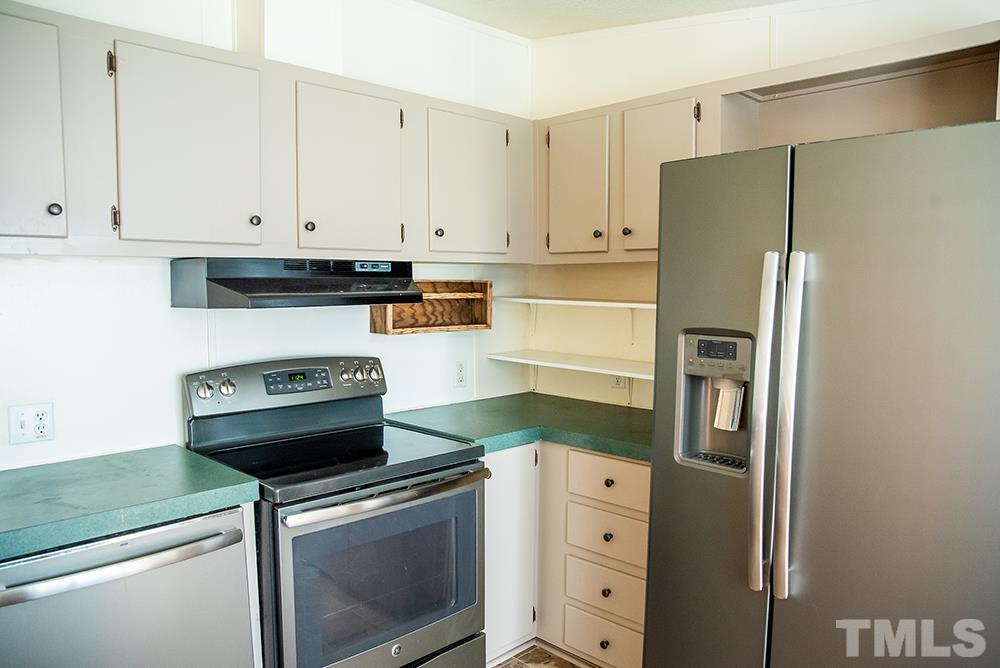 800 Woodsdale Road Roxboro, NC 27574 - Photo 5 of 54 a kitchen with cabinets and stainless steel appliances