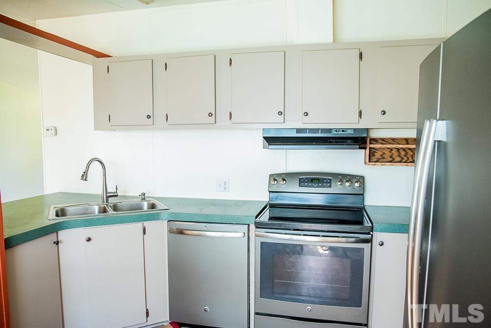800 Woodsdale Road Roxboro, NC 27574 - Photo 8 of 54 a kitchen with granite countertop white cabinets and stainless steel appliances