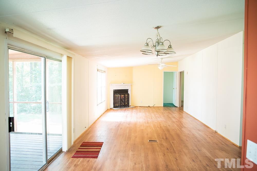 800 Woodsdale Road Roxboro, NC 27574 - Photo 10 of 54 a view of a livingroom with wooden floor and a chandelier