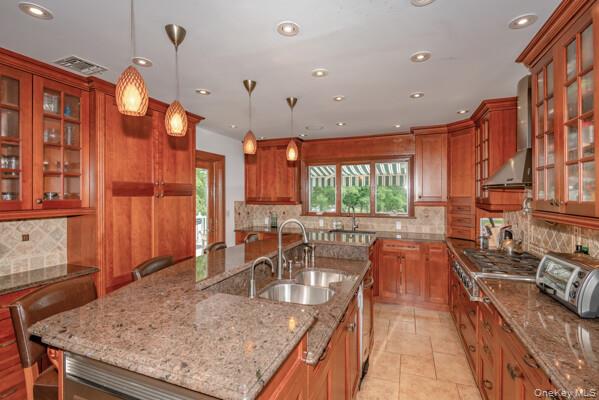 27 West Tiana Road Hampton Bays, NY 11946 - Photo 10 of 21 a kitchen with stainless steel appliances granite countertop a sink a stove and a wooden cabinets