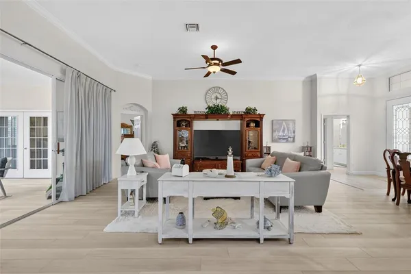 a view of a dining room with furniture a chandelier and wooden floor
