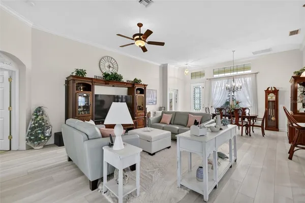 a living room with furniture a chandelier and a wooden floor