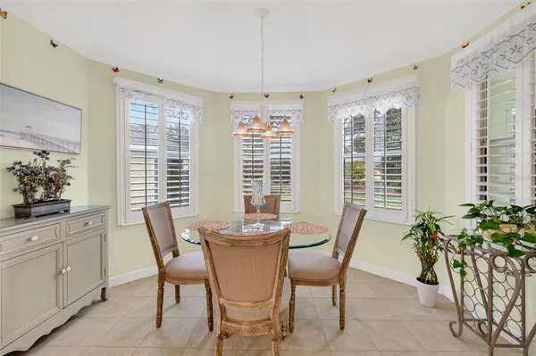 a dining room with furniture potted plants and wooden floor