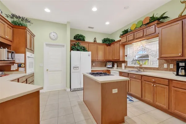 a kitchen with a sink a refrigerator a stove and cabinets
