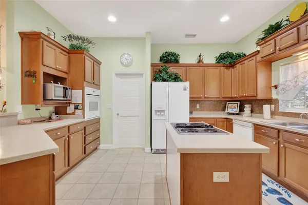 a kitchen with stainless steel appliances granite countertop a refrigerator a stove and a sink