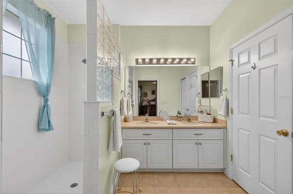 a spacious bathroom with a double vanity sink a mirror and shower