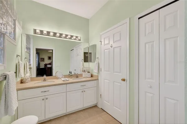 a spacious bathroom with a double vanity sink a mirror and a shower