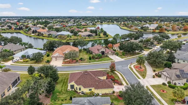 an aerial view of residential houses with outdoor space and lake view