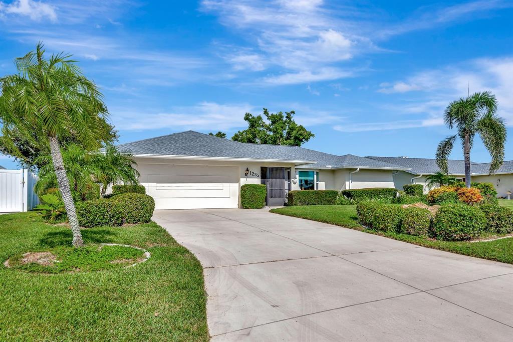 1235 Pine Needle Road Venice, FL 34285 - Photo 57 of 74 a view of a house with a yard and potted plants