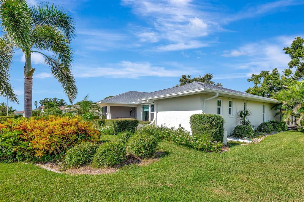 1235 Pine Needle Road Venice, FL 34285 - Photo 59 of 74 a view of a yard in front of a house with plants and large tree