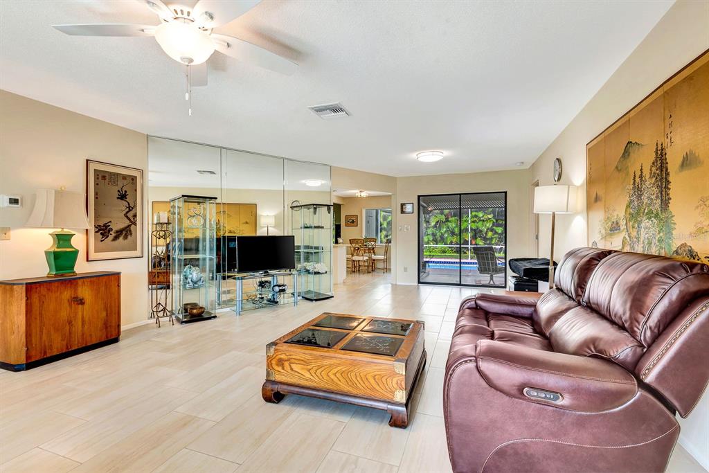 1235 Pine Needle Road Venice, FL 34285 - Photo 6 of 74 a living room with furniture and a flat screen tv