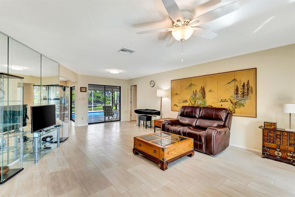 1235 Pine Needle Road Venice, FL 34285 - Photo 7 of 74 a living room with furniture and a flat screen tv