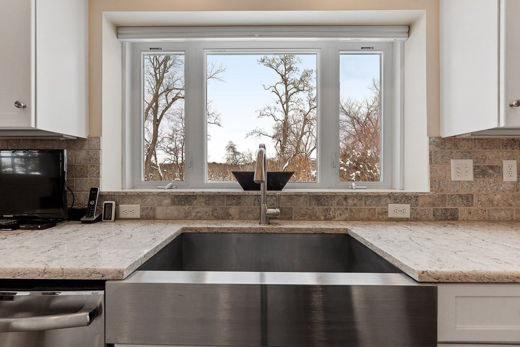 212 Hawthorne Lane Concord, MA 01742 - Photo 14 of 41 a view of a kitchen counter top space a sink and a window