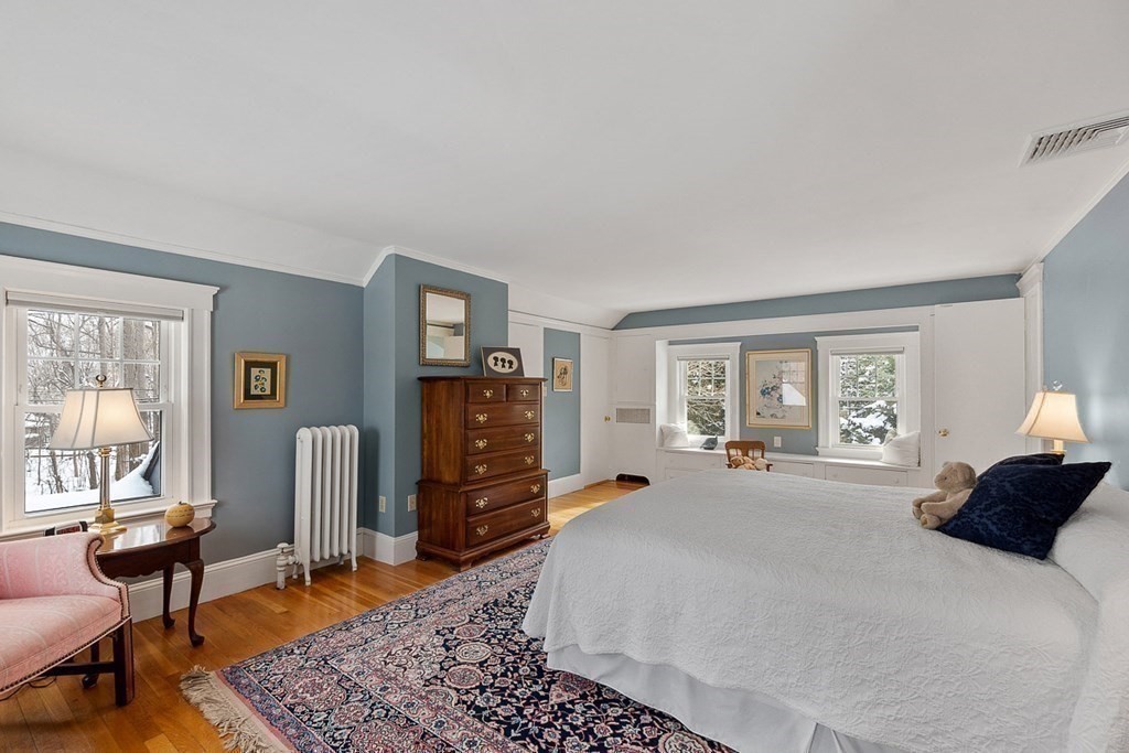 212 Hawthorne Lane Concord, MA 01742 - Photo 27 of 41 a large bedroom with a bed a table and chair with a bookshelf