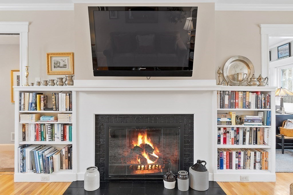 212 Hawthorne Lane Concord, MA 01742 - Photo 7 of 41 a living room with bookshelf and a fireplace