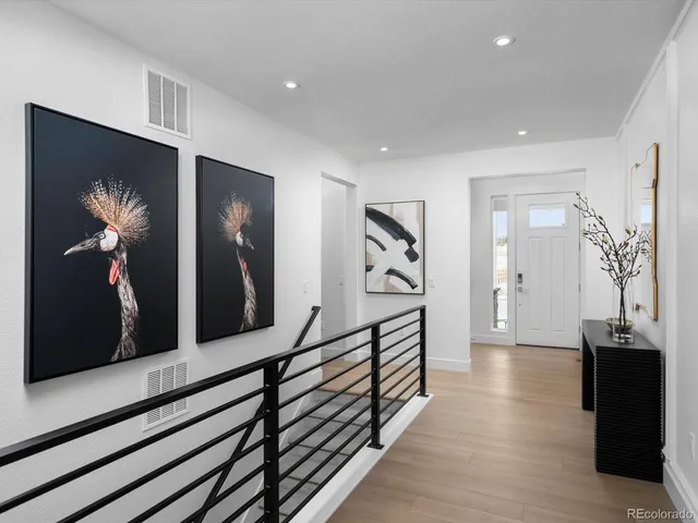 a view of a hallway with wooden floor and stairs