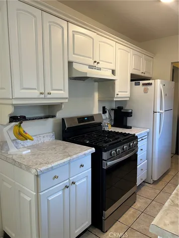 a kitchen with stainless steel appliances granite countertop a stove a refrigerator and a sink