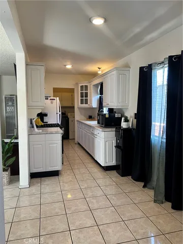 a kitchen with granite countertop a refrigerator and a stove top oven