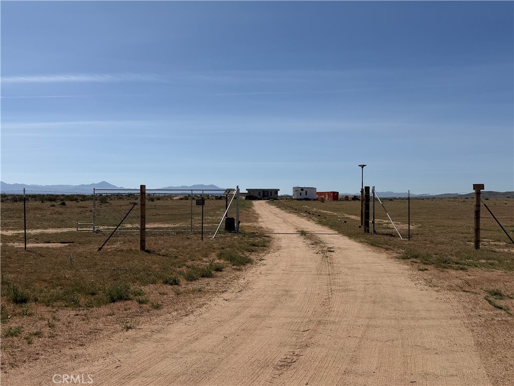 21353 Riverview Road Barstow, CA 92311 - Photo 2 of 24 a view of a dry yard with wooden fence