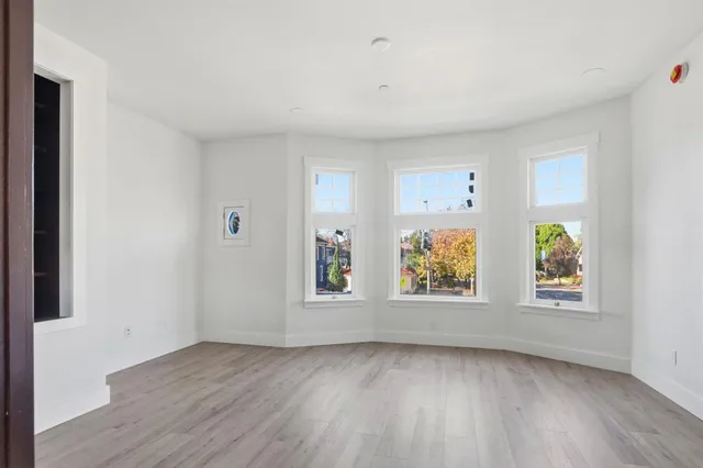 an empty room with windows and wooden floor