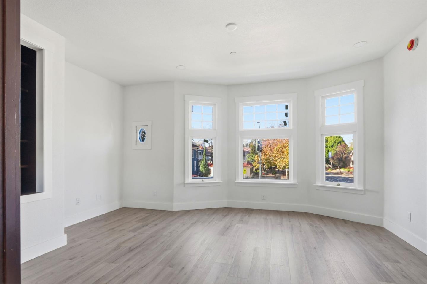 an empty room with windows and wooden floor
