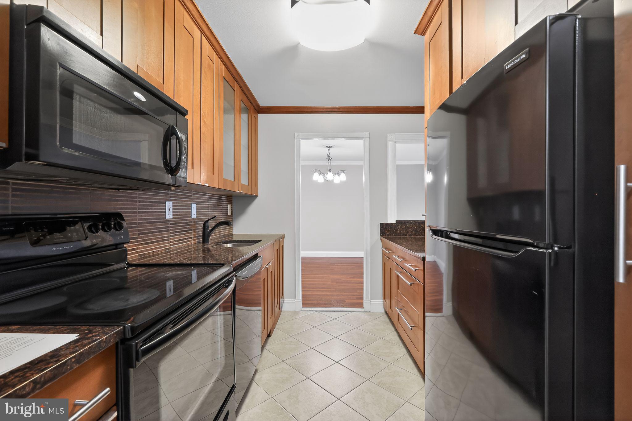 9701 Fields Road, Unit 1904 Gaithersburg, MD 20878 - Photo 19 of 31 a kitchen with granite countertop a sink stove and refrigerator