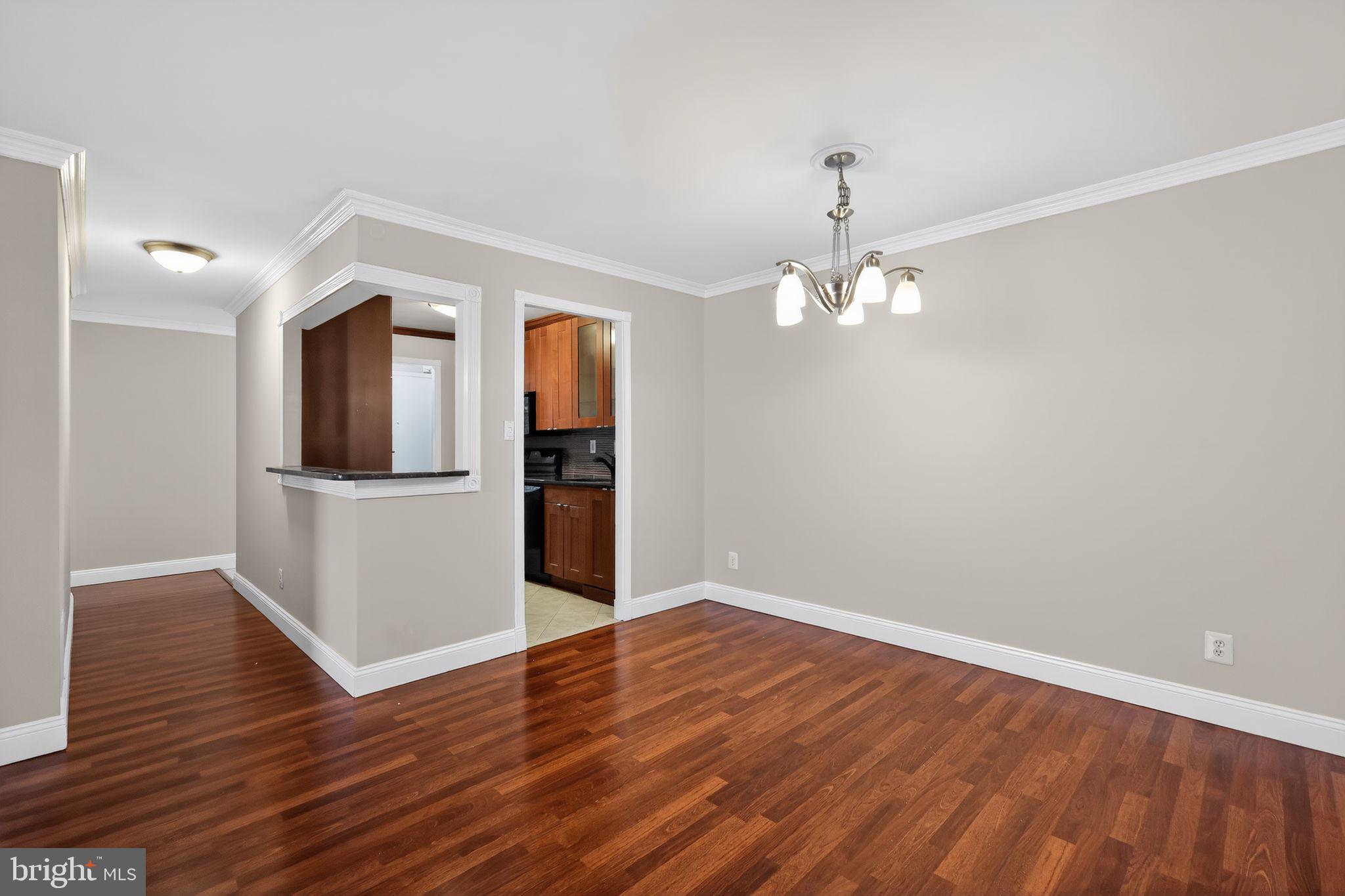 9701 Fields Road, Unit 1904 Gaithersburg, MD 20878 - Photo 21 of 31 a view of a room with wooden floor staircase and a kitchen space