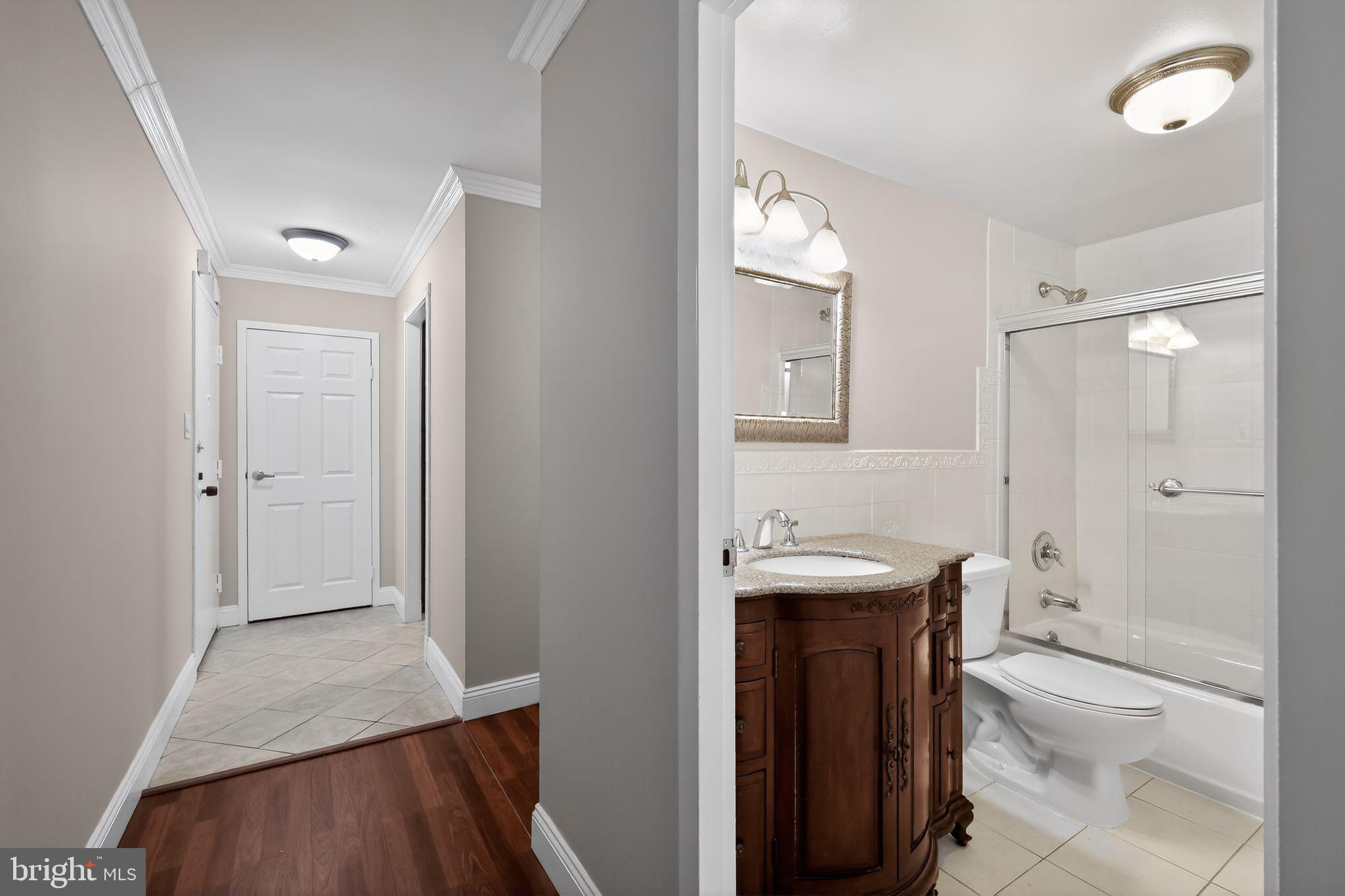 9701 Fields Road, Unit 1904 Gaithersburg, MD 20878 - Photo 24 of 31 a bathroom with a sink a toilet a shower and a mirror