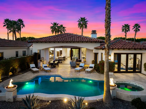 a view of a patio with table and chairs potted plants and palm tree