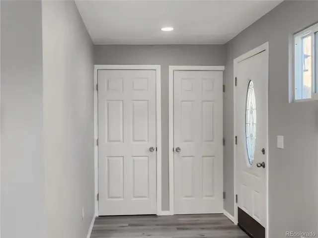 a kitchen with wooden floors white cabinets and stainless steel appliances