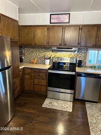 a kitchen with stainless steel appliances granite countertop a stove a refrigerator and a sink