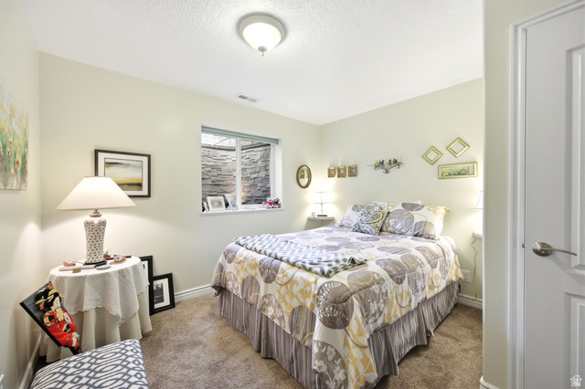 776 Flint Street Layton, UT 84041 - Photo 15 of 41 Bedroom featuring a window with a stone-look exterior, neutral-toned walls, and textured carpet flooring