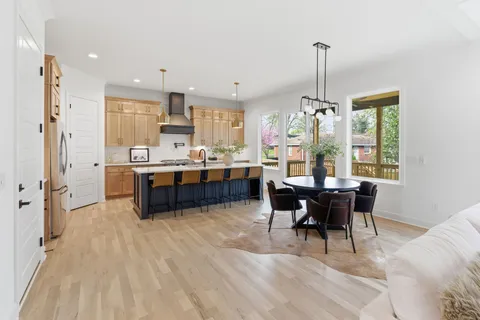 a view of a dining room and livingroom with furniture wooden floor a chandelier