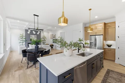 a kitchen with stainless steel appliances granite countertop a sink a stove and a wooden floors