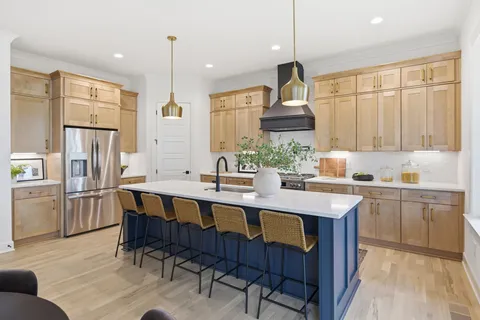 a kitchen with stainless steel appliances granite countertop a table chairs sink refrigerator and cabinets